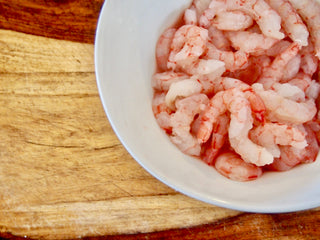 Peeled and Deveined Royal Red Shrimp in Bowl on top of wooden cutting board 