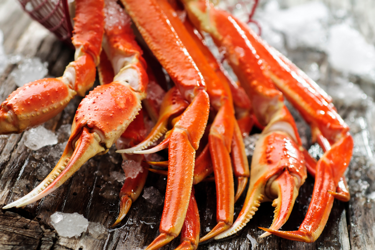 Snow crab clusters on ice on top of wood