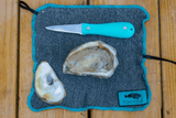 Oyster knife, shucked oyster on top of cut-proof oyster shucking cloth thumbnail